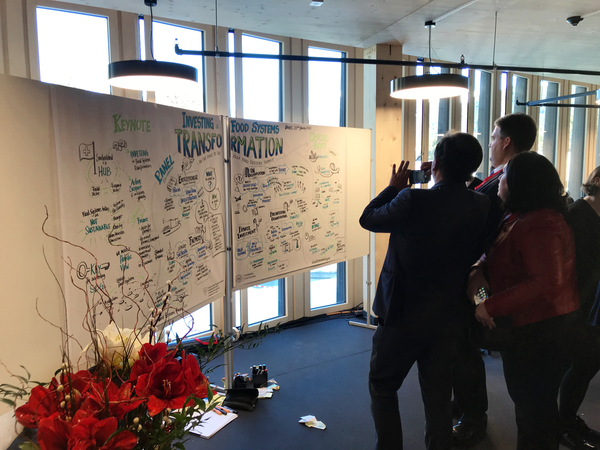 People taking picutres of the finalized Graphic Recording