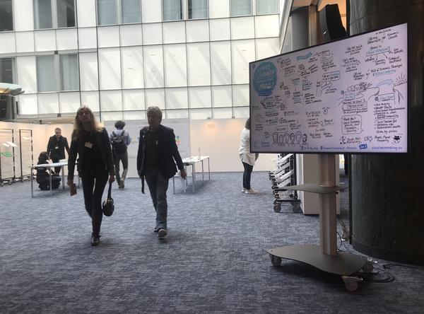 Graphic Recording visuals were displayed on screens in the hall